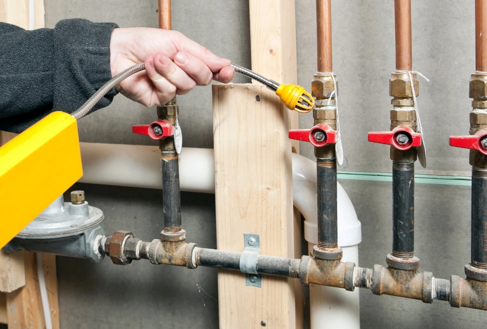 Certified technician performing a gas line pressure test on a new manifold installation to ensure a leak-free system