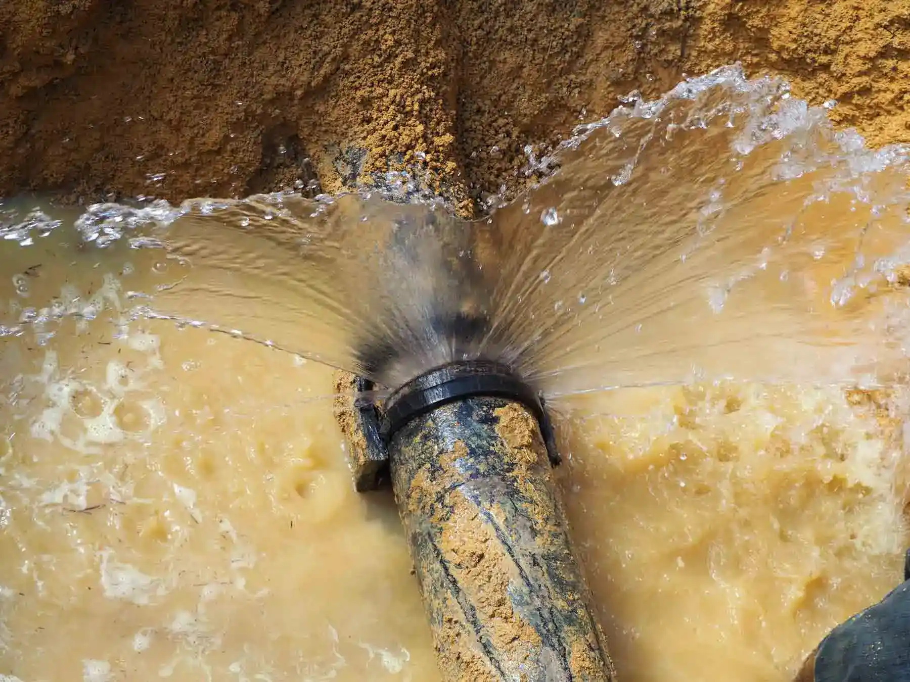 Underground main water line burst at a pipe junction during a residential water line repair project