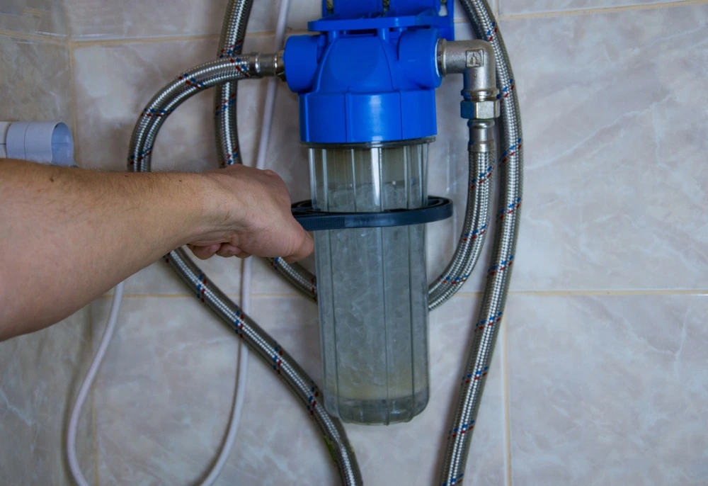 A professional whole house water softener and carbon filtration system installed in a residential utility room